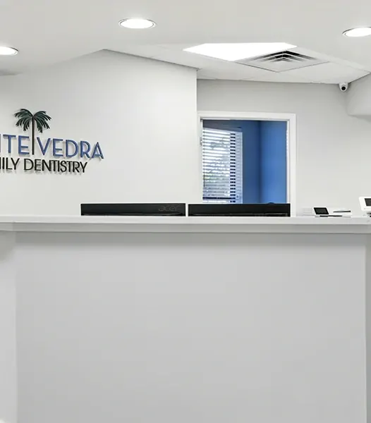 The front desk, with the practice's palm logo on the wall.